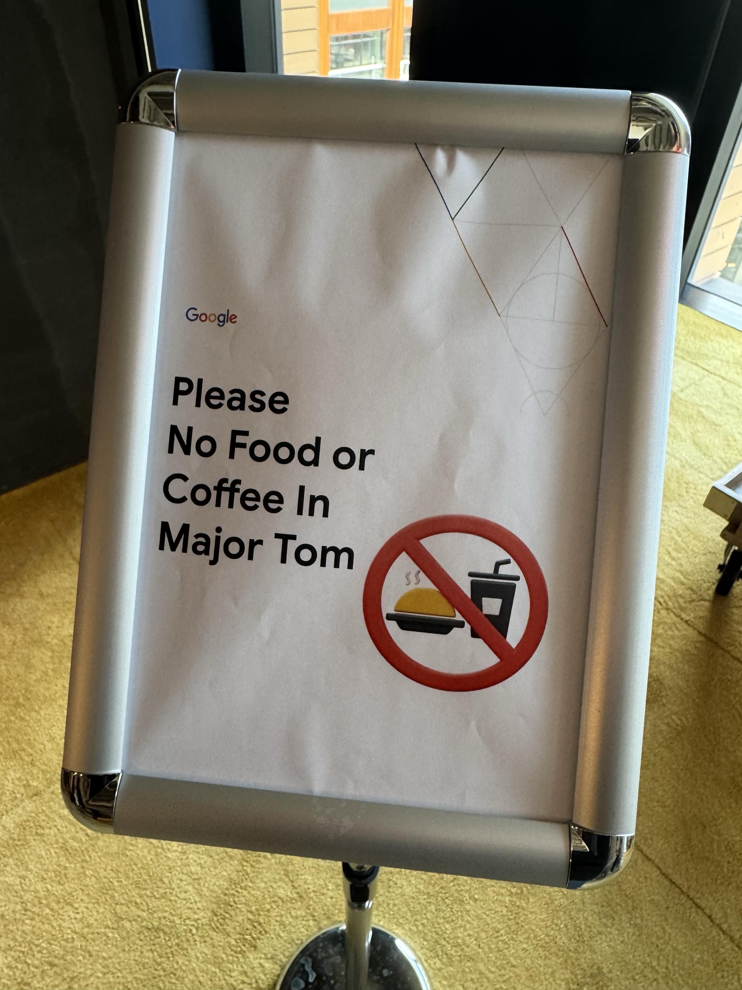 A sign from Google stating "Please No Food or Coffee In Major Tom" with a graphic symbol indicating food and drink prohibition.
